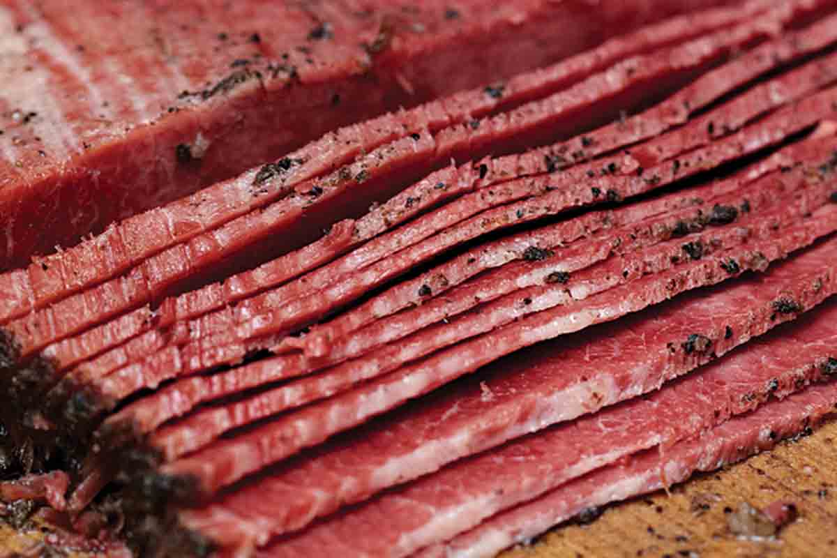 sliced pastrami on a wooden board